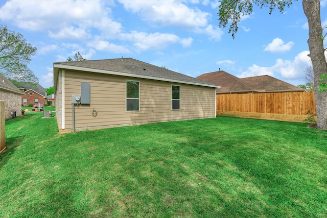 back of house with a yard and fence