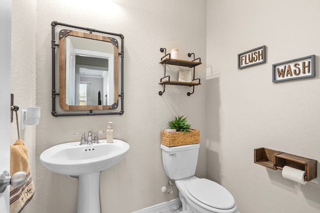 bathroom featuring toilet and baseboards