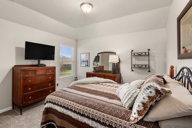 carpeted bedroom featuring lofted ceiling and baseboards