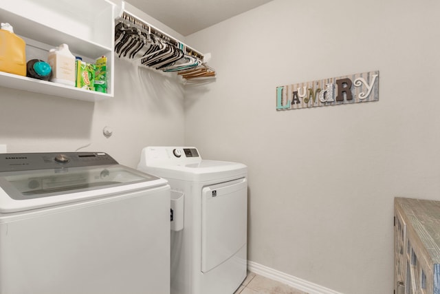 washroom featuring laundry area, baseboards, light tile patterned flooring, and independent washer and dryer