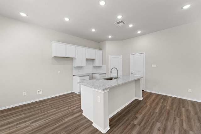 kitchen with visible vents, white cabinets, an island with sink, dark wood-style flooring, and a sink