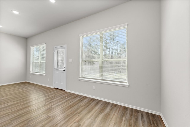 interior space featuring recessed lighting, baseboards, and wood finished floors