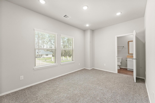 carpeted spare room with baseboards, visible vents, and recessed lighting