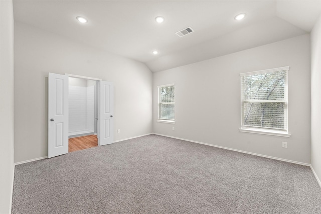 unfurnished room featuring lofted ceiling, recessed lighting, visible vents, carpet flooring, and baseboards