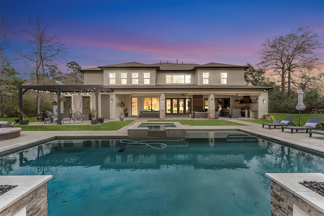 rear view of house featuring a pool with connected hot tub, stucco siding, a patio, and a pergola