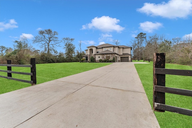 view of front of home with fence, concrete driveway, and a front yard