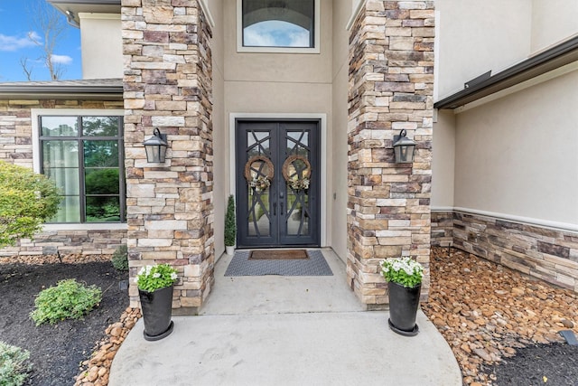 doorway to property featuring stone siding and stucco siding