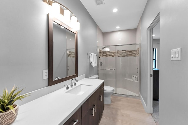 full bathroom featuring recessed lighting, visible vents, toilet, a stall shower, and vanity