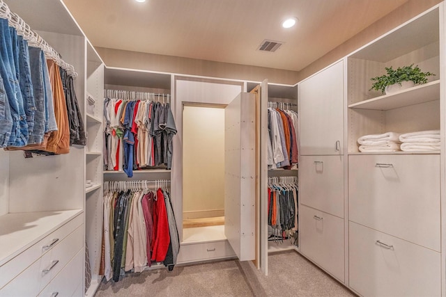 walk in closet featuring light carpet and visible vents