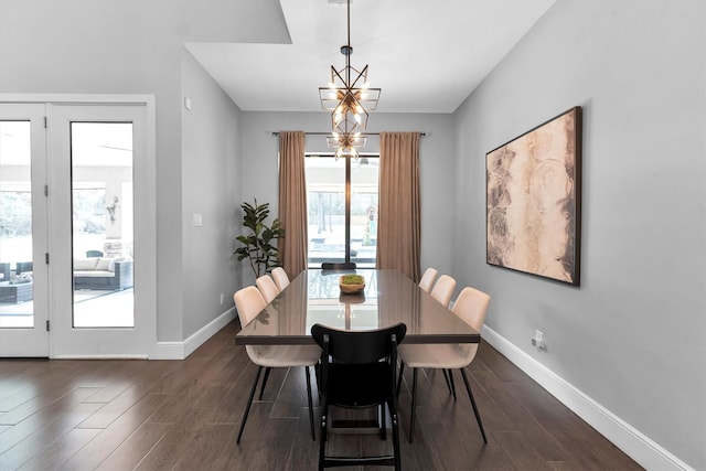 dining area with dark wood-style flooring, an inviting chandelier, and baseboards