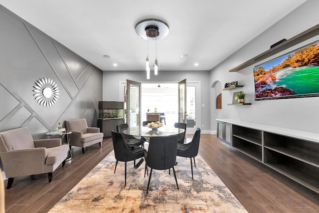 dining space with baseboards, arched walkways, dark wood-style flooring, and recessed lighting