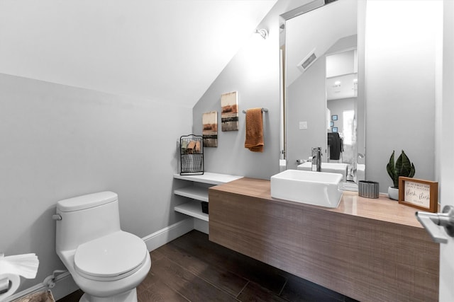 half bath featuring baseboards, visible vents, lofted ceiling, toilet, and wood finished floors