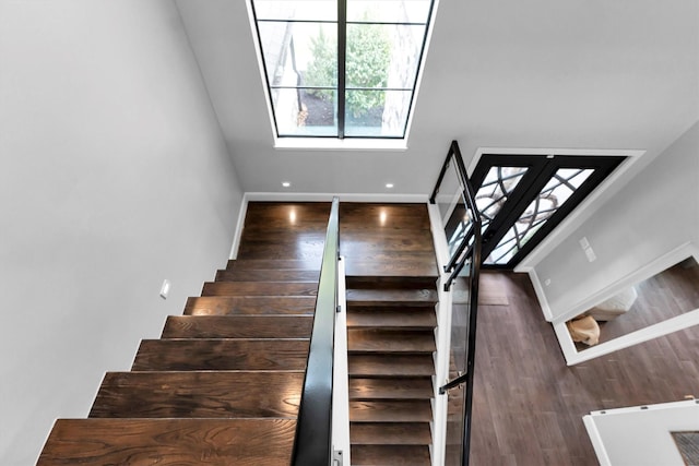 stairs featuring wood finished floors and baseboards