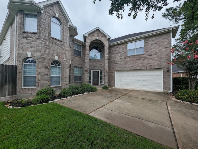 traditional-style home featuring a garage, a front lawn, concrete driveway, and brick siding