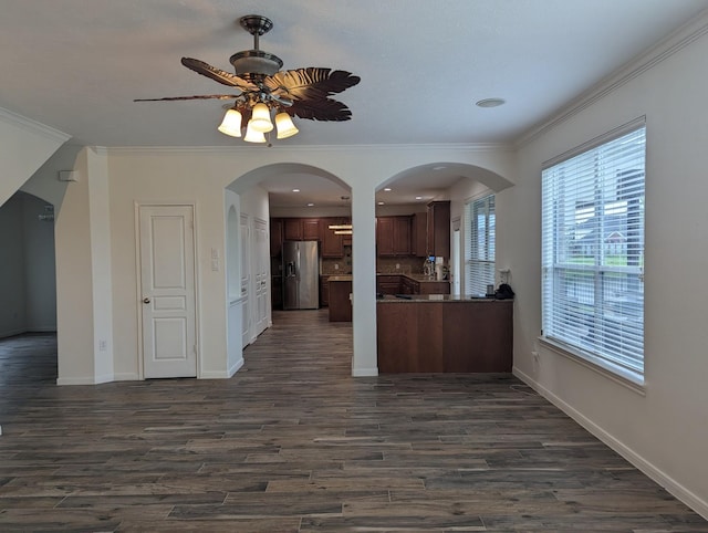 kitchen with dark wood-type flooring, stainless steel fridge, crown molding, and a ceiling fan