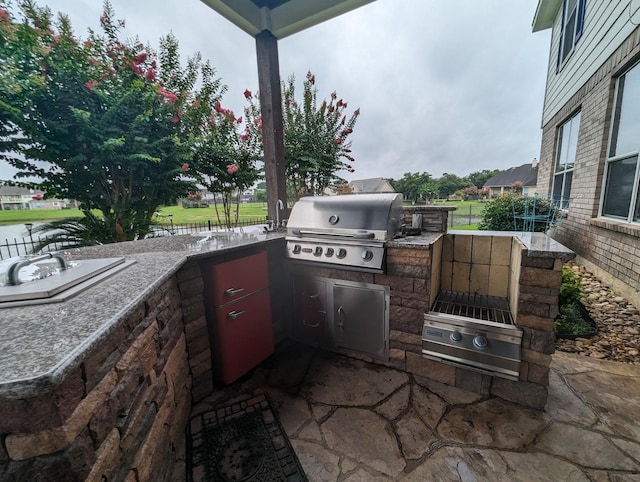 view of patio / terrace with exterior kitchen, fence, and grilling area