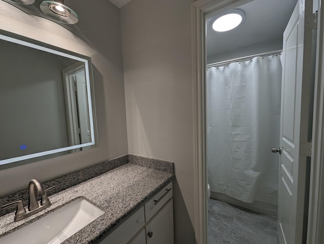 bathroom featuring toilet, curtained shower, and vanity