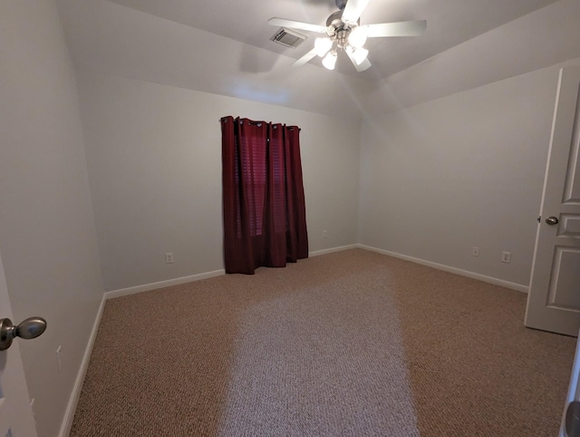 carpeted spare room with ceiling fan, vaulted ceiling, visible vents, and baseboards