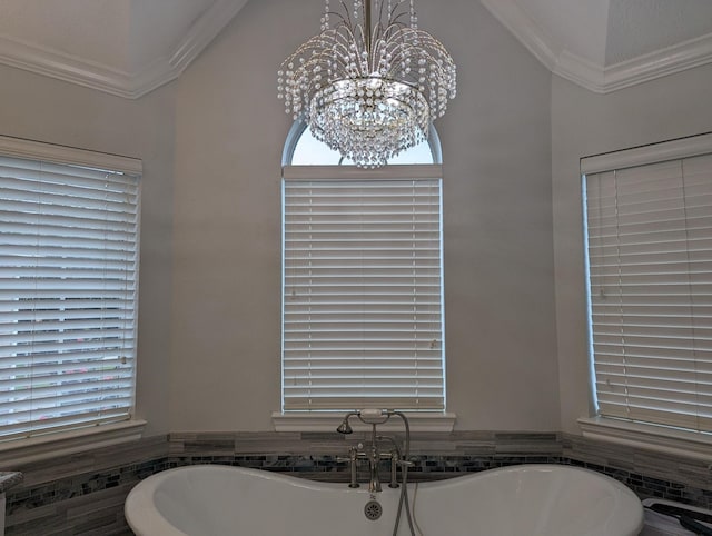 bathroom featuring a freestanding bath, ornamental molding, a wainscoted wall, and a notable chandelier