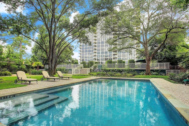 outdoor pool featuring a patio area and fence