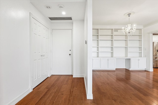 interior space featuring baseboards, hardwood / wood-style floors, visible vents, and an inviting chandelier