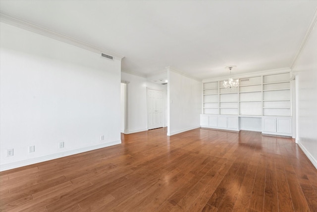 unfurnished room featuring visible vents, ornamental molding, a chandelier, baseboards, and hardwood / wood-style flooring