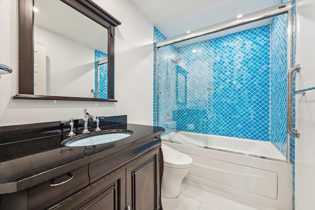 bathroom featuring toilet, tile patterned flooring, enclosed tub / shower combo, and vanity