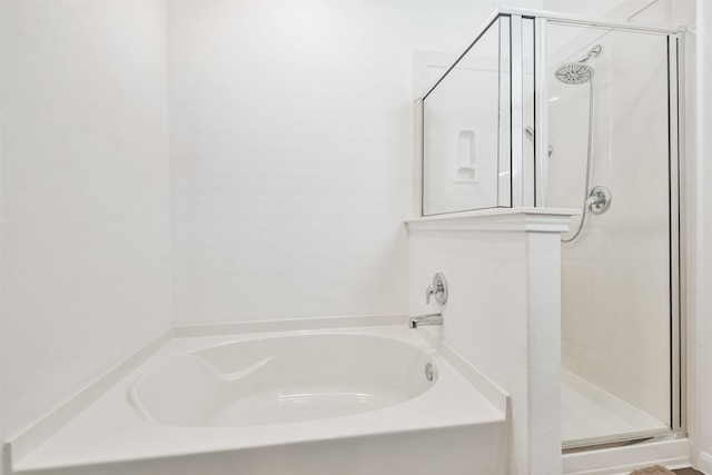 bathroom featuring a stall shower and a garden tub