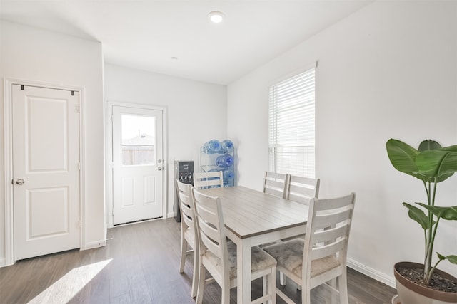 dining space featuring baseboards and wood finished floors