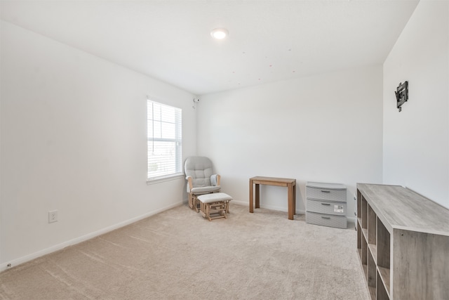 living area with light carpet and baseboards