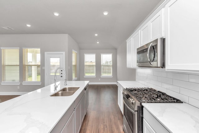 kitchen featuring recessed lighting, stainless steel appliances, dark wood-type flooring, a sink, and backsplash