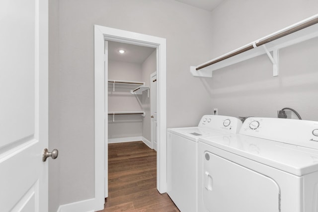 laundry room with laundry area, washing machine and clothes dryer, dark wood finished floors, and baseboards