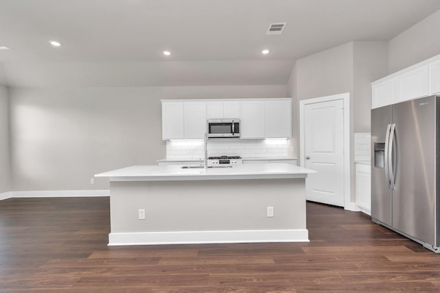 kitchen featuring stainless steel appliances, dark wood-style flooring, visible vents, decorative backsplash, and an island with sink