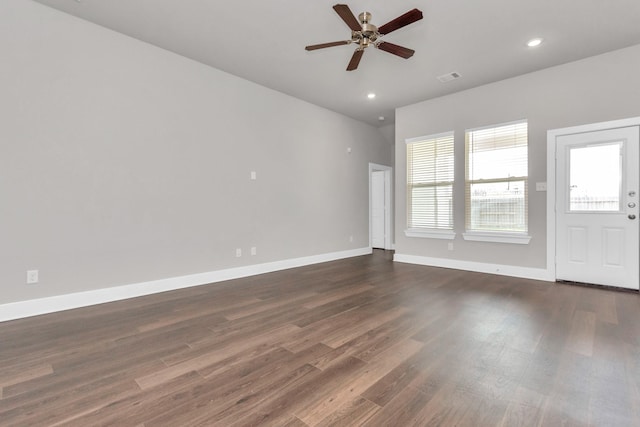 empty room with dark wood-style floors, recessed lighting, visible vents, and baseboards