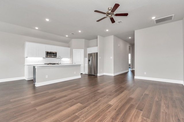 unfurnished living room featuring a ceiling fan, visible vents, dark wood-type flooring, and recessed lighting