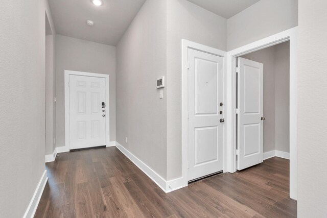 entryway with dark wood finished floors and baseboards