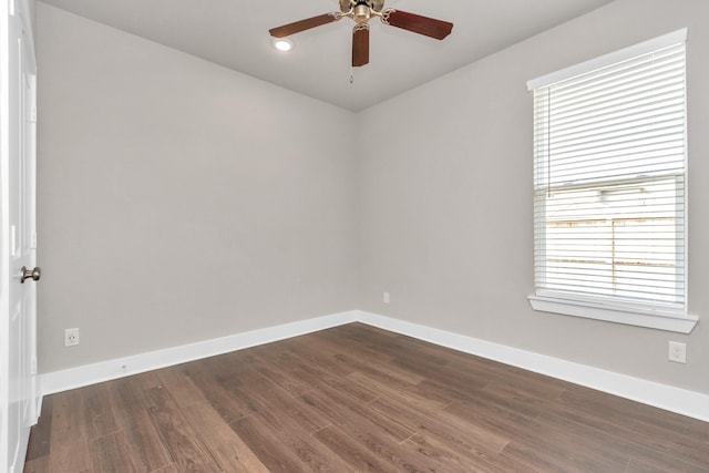 spare room with dark wood-style floors, baseboards, and a ceiling fan