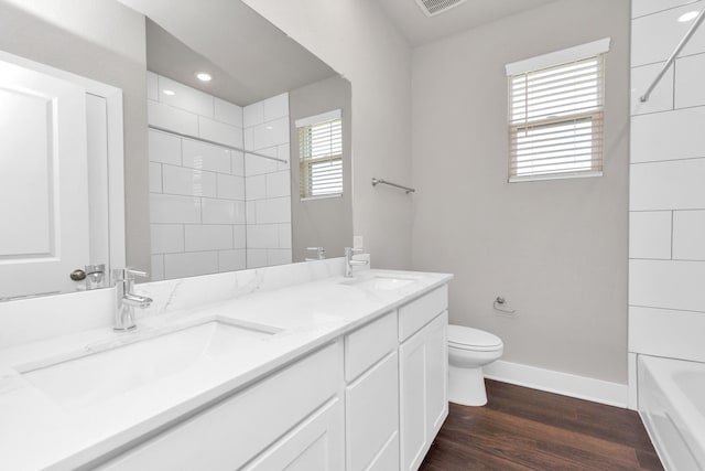 full bathroom with baseboards, a sink, toilet, and wood finished floors