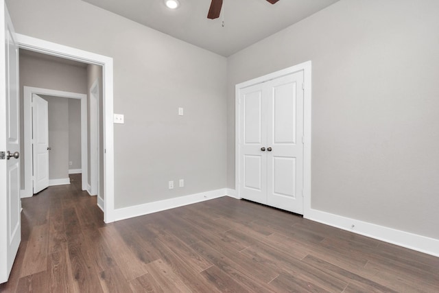 unfurnished bedroom featuring dark wood-style floors, baseboards, and a ceiling fan