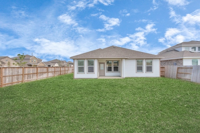 rear view of property with a lawn and a fenced backyard