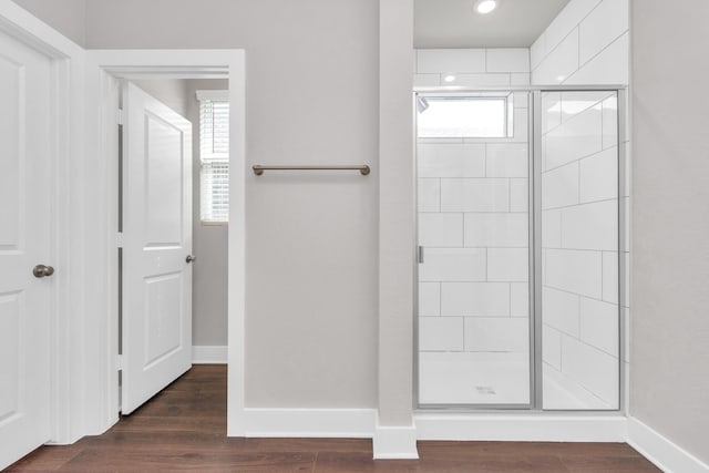 full bath featuring baseboards, recessed lighting, wood finished floors, and a shower stall