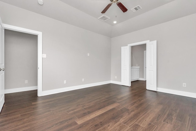 spare room featuring baseboards, visible vents, and dark wood finished floors