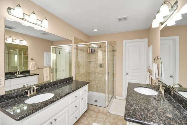 bathroom featuring a stall shower, a sink, and visible vents