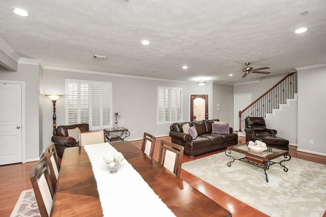 dining room featuring stairway, wood finished floors, crown molding, a textured ceiling, and recessed lighting