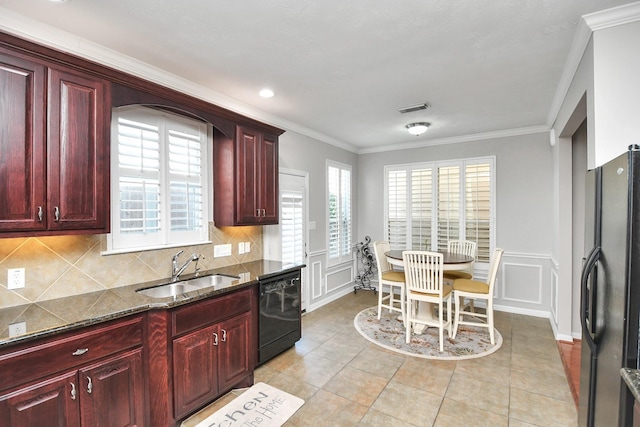 kitchen featuring reddish brown cabinets, visible vents, a sink, and black appliances