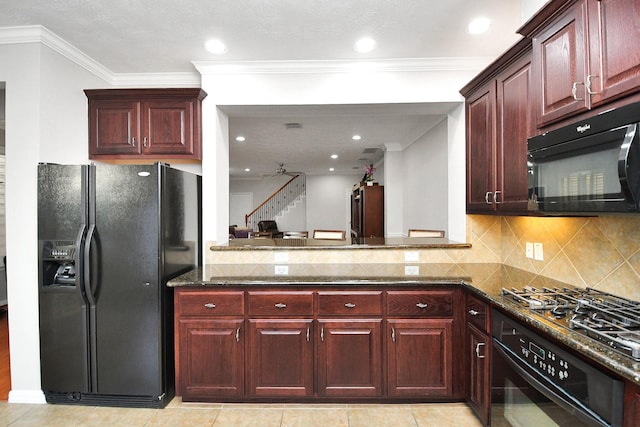 kitchen featuring dark brown cabinets, ornamental molding, decorative backsplash, dark stone counters, and black appliances