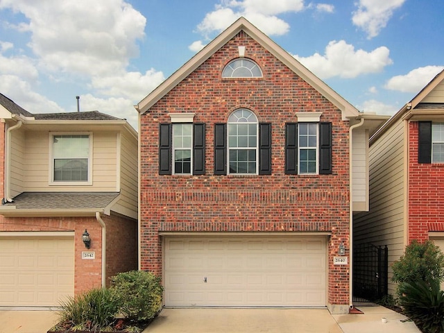 traditional-style home with driveway, brick siding, and an attached garage