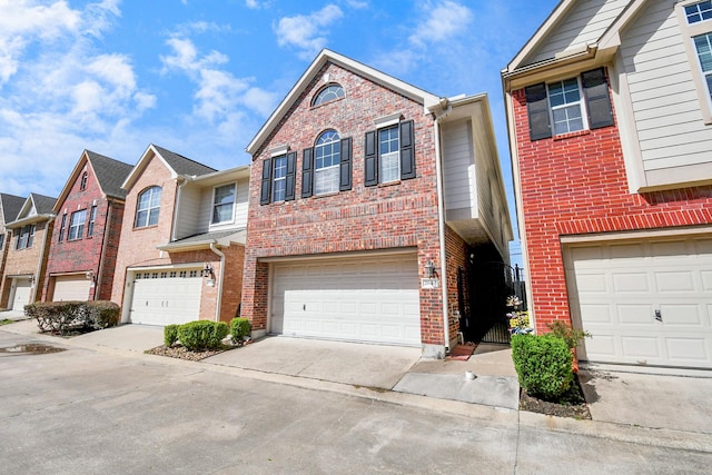 townhome / multi-family property featuring a garage, brick siding, and driveway