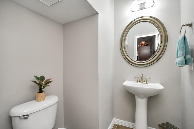 bathroom featuring toilet and baseboards