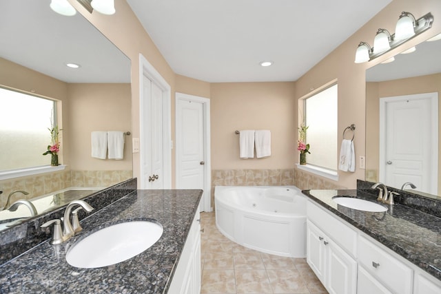 full bathroom with two vanities, a sink, a tub with jets, and tile patterned floors